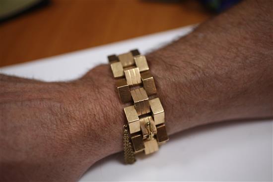 A stylish 18ct gold articulated triangular hollow link bracelet, 136 grams.
